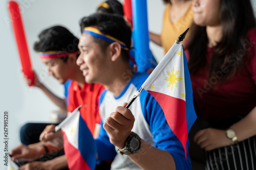 filipino group of people holding philippines flag celebrating independence day