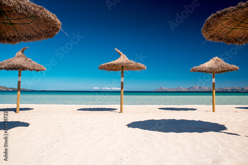 Straw umbrellas on a tropical beach. Summer holiday concept photo