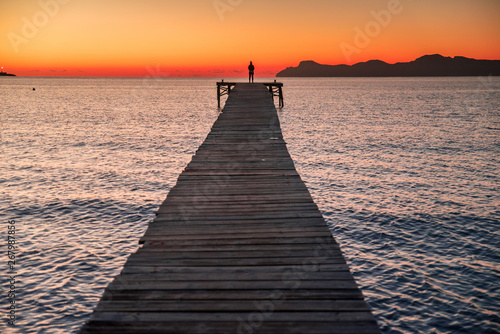 silhouette a woman on pier at coast