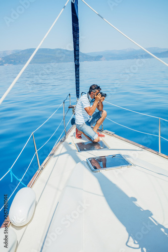 Young man making photo on the yacht. Holidays, people, travel