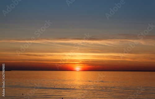 Fototapeta Naklejka Na Ścianę i Meble -  Beautiful sunset over the sea. The sun sets on the water. The sky is painted with bright colors. Sunset beach in a summer evening. Gulf of Finland, Baltic sea, Kronstadt, Saint-Petersburg, Russia.