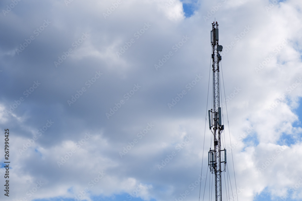 Mobile phone cellular tower silhouette with blue sky.