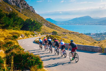 Sporty friends on bicycle on sunset light in beautiful nature by the sea. Road cycling on the coast. Sport in Nature background. Teamwork concept photo