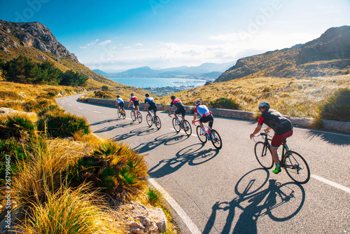 Fototapeta Naklejka Na Ścianę i Meble -  Team sport cyclist photo. Group of triathlete on bicycle ride on the road at Mallorca, Majorca, Spain.