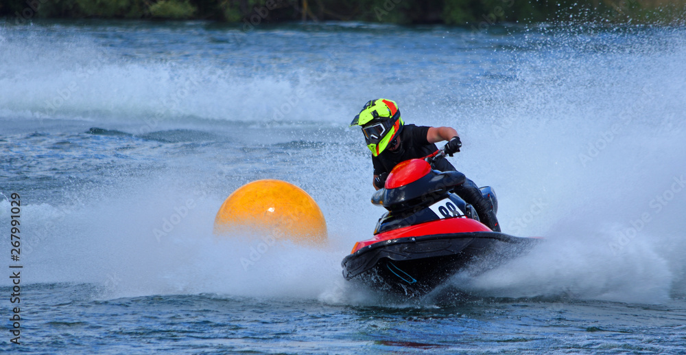 Jet Ski competitor cornering at speed around yellow buoy creating at lot of spray.