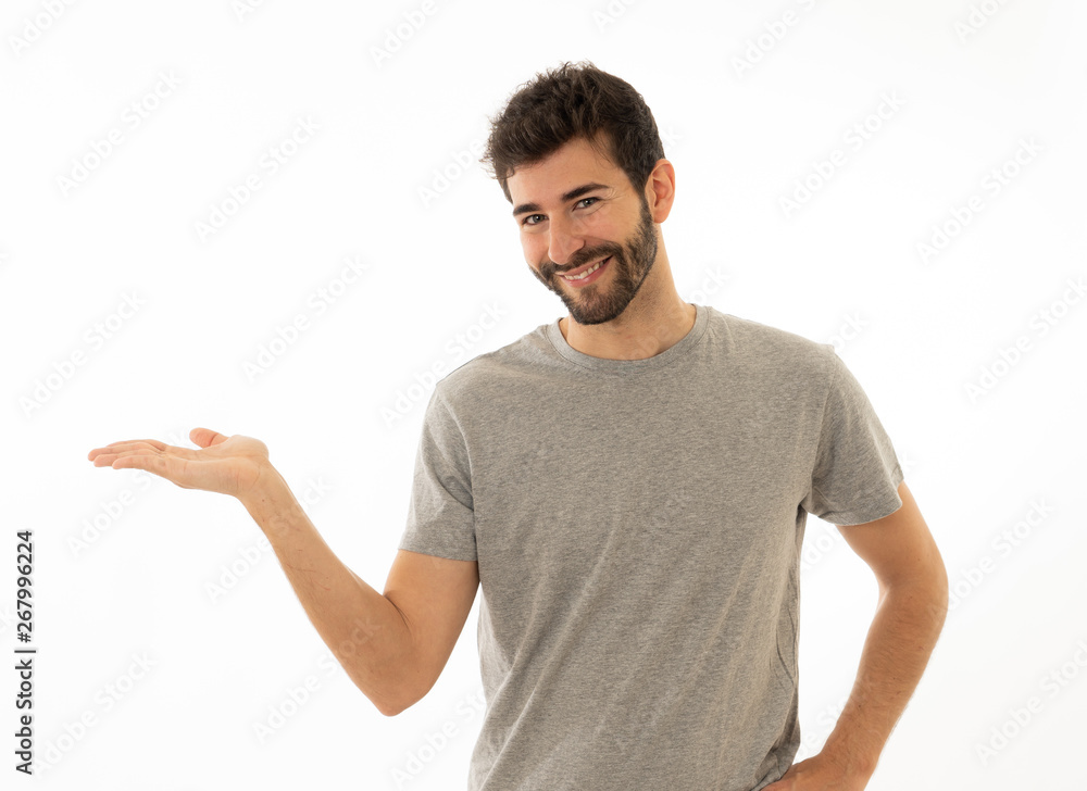 Charming smiling young man pointing finger at empty copy space for advertisement Charming smiling young man pointing finger at empty copy space for advertisement