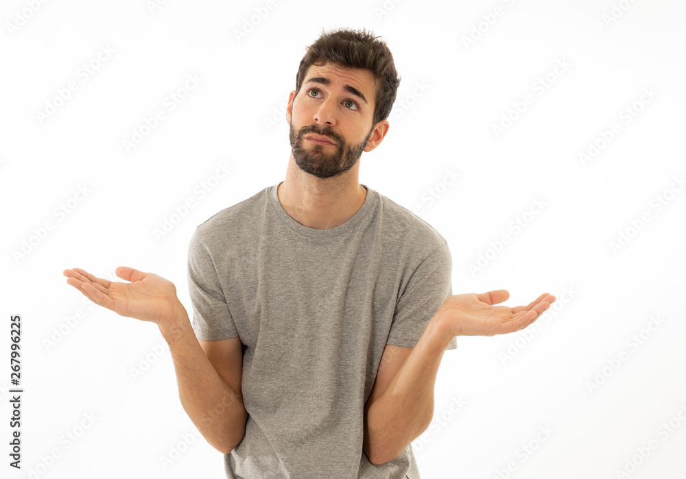 Good looking man with no idea, oops sorry or I do not care gesture smiling at the camera Good looking man with no idea, oops sorry or I do not care gesture smiling at the camera