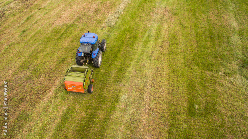 bird eye of Man at work on the tractor with hay baler bird eye of Man at work on the tractor with hay baler