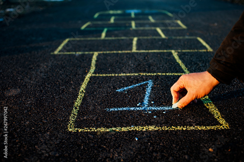 A young man draws hopscotch on asphalt. Good mood and spring in Russia. A bearded man recalls his childhood. photo