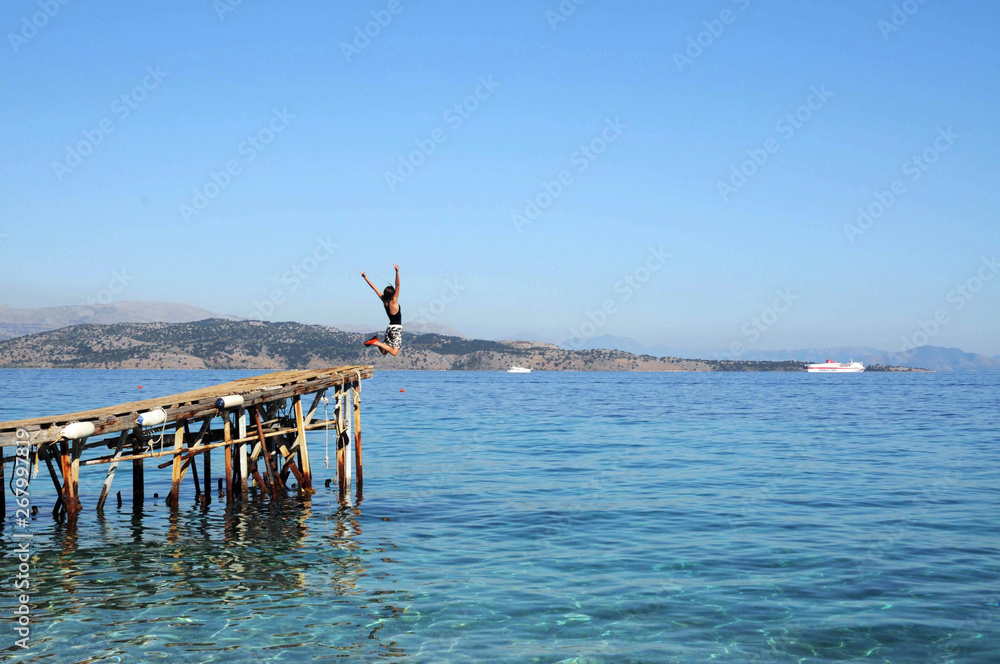 Girl leaping into the sea, on holiday