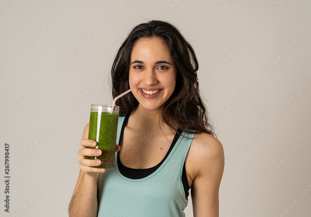 Happy beautiful fit sport woman smiling and drinking healthy fresh vegetable detox smoothie Happy beautiful fit sport woman smiling and drinking healthy fresh vegetable detox smoothie