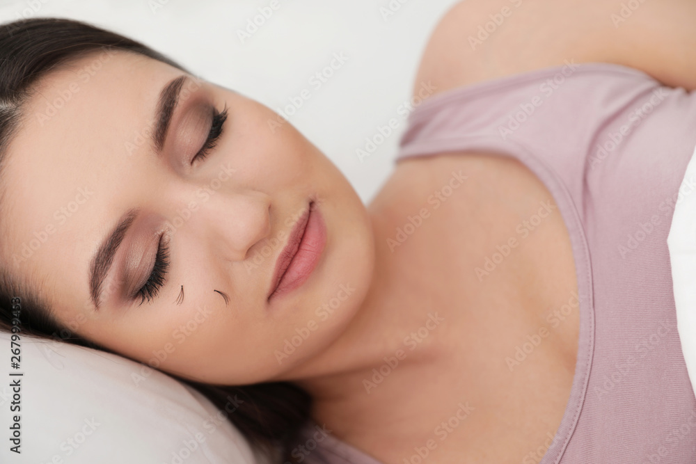 Young woman with eyelash loss problem sleeping in bed