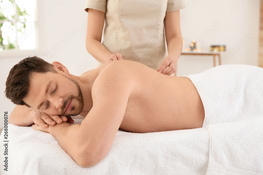 Handsome man receiving back massage in spa salon Handsome man receiving back massage in spa salon