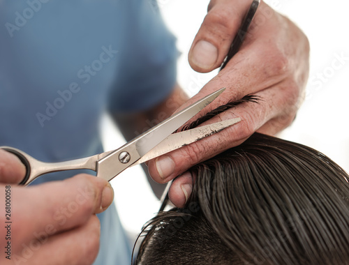 Haircutting process in the hairdresser. man in the salon smoothes his hair. Hands with scissors. Stock photos for design