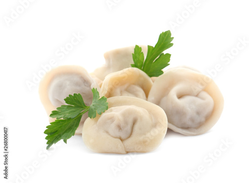 Pile of boiled dumplings with parsley leaves on white background