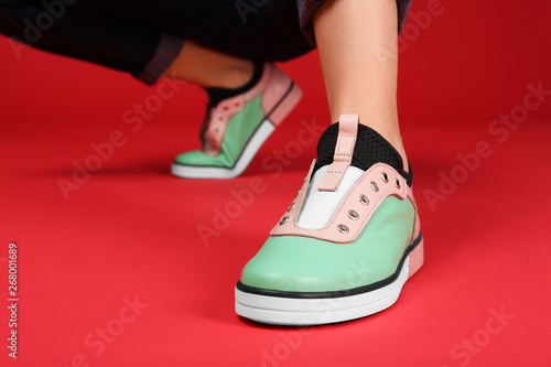 Woman in stylish shoes on color background