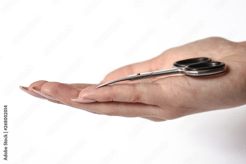 Manicure scissors on the hand of a young girl. Female beauty and body care. Stock photo Manicure scissors on the hand of a young girl. Female beauty and body care. Stock photo