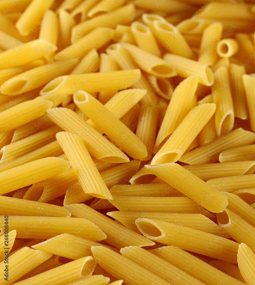 Penne rigate pasta pile background and texture, side view Penne rigate pasta pile background and texture, side view