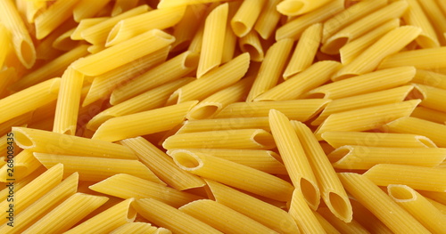  Penne rigate pasta pile background and texture, side view
