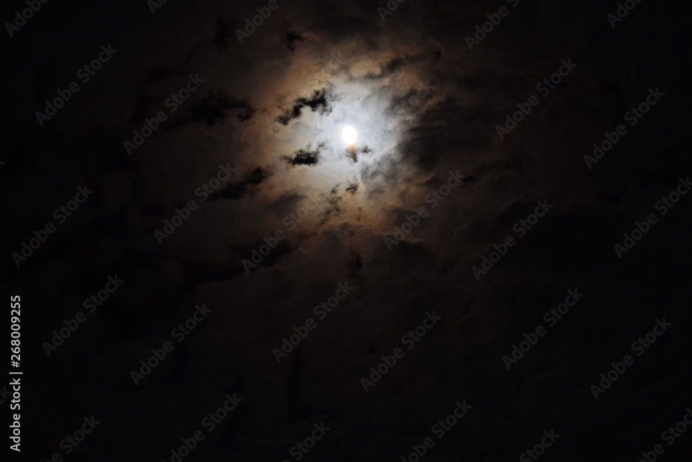 The night sky, moon hiding behind the clouds The night sky, moon hiding behind the clouds