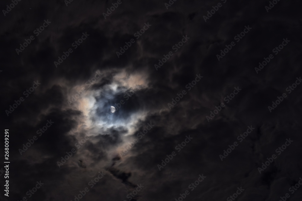 The night sky, moon hiding behind the clouds The night sky, moon hiding behind the clouds