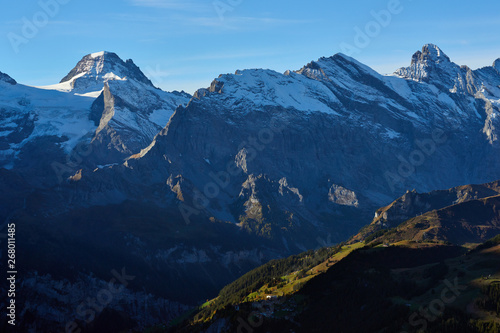 The morning panorama of the mountains with the peaks and mountainsides illuminated by sunlight in Lauterbrunnen valley in Switzerland.
