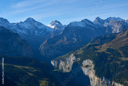 The morning panorama of the mountains with the peaks and rocks illuminated by sunlight in Lauterbrunnen valley in Switzerland. © thecolorpixels
