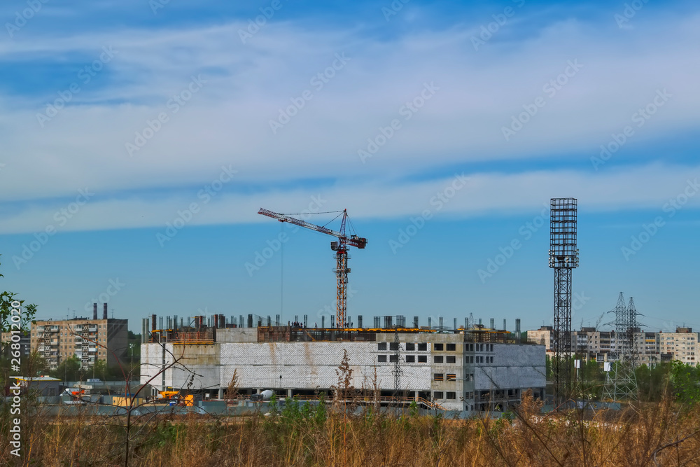 Construction of a mall cranes on a background of blue sky Construction of a mall cranes on a background of blue sky