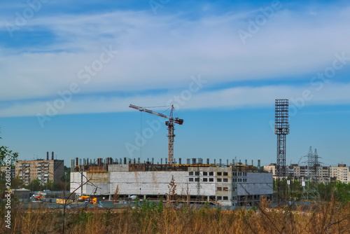 Construction of a mall cranes on a background of blue sky