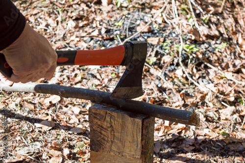 Close-up Man's Hand Cuts Wooden Stick With An Ax