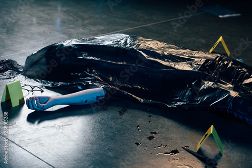 covered corpse with glasses on floor at crime scene photo