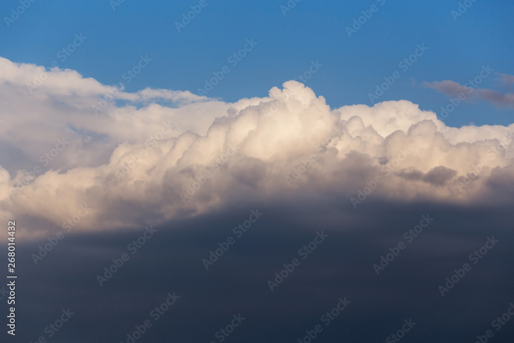 Obraz premium Epic dramatic cumulus fluffy white clouds in sunlight against blue sky background, heaven texture