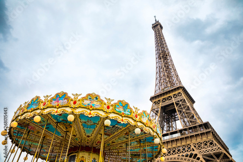 View from the bottom of The Eiffel Tower and Carousel in Paris in cloudy day, France