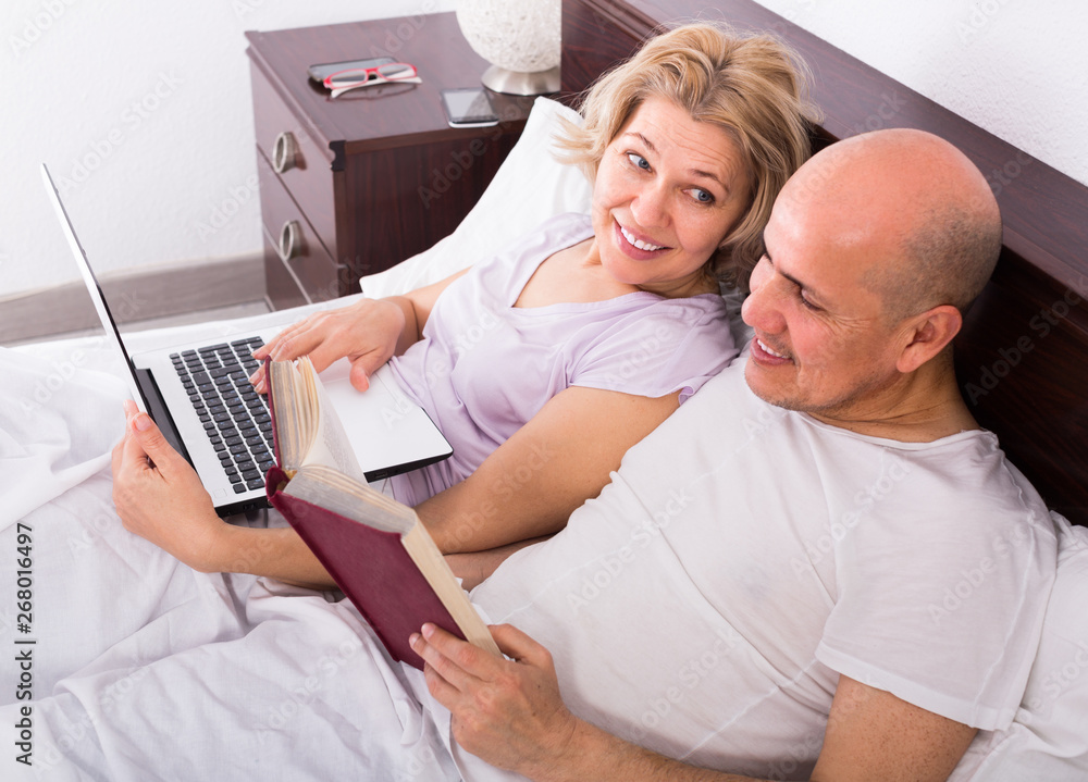 Fototapeta premium Mature couple in bed with laptop .