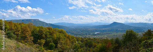 Autumn panorama of a quiet valley covered with bluish haze and mountains in Adygea near the Lagonaki Plateau