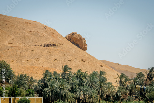 Mountain with sign welcoming Aswan on the bank of the Nile River. Egypt.