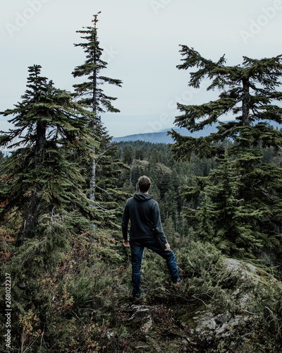 man standing near green leafed trees photo