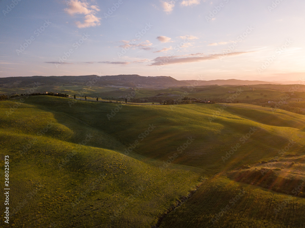 Colline con campi di grano coltivati in val d'orcia Toscana al tramonto