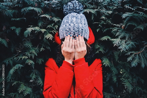 woman covering her face beside leaf plants photo