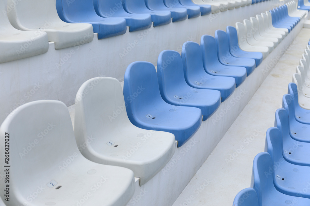 Fototapeta premium Empty stadium seats close up. Stadium chairs. Row after row of blue and white stadium seats.