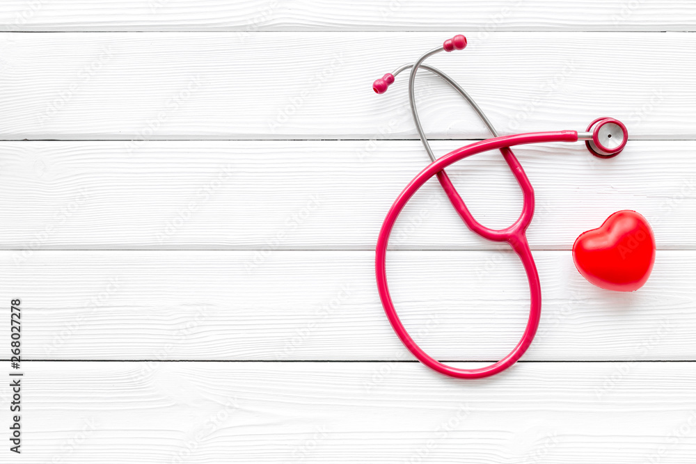 Φωτογραφία diagnostic and cure of cardiac disease with stethoscope and heart on white woode