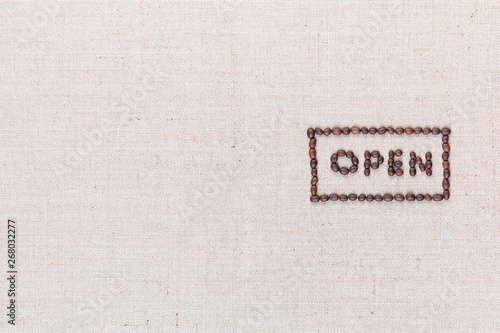 The word Open inside a rectangle written with coffee beans,aligned to the right.