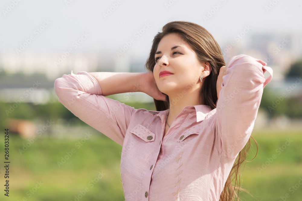 Happy young fashion woman in pink shirt walking outdoor