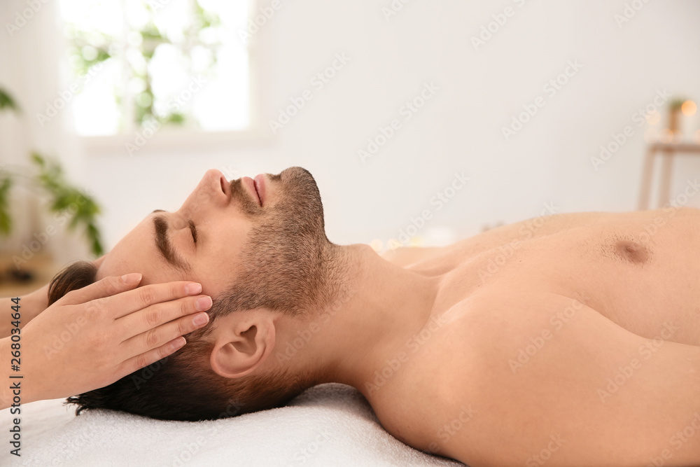 Handsome man receiving face massage in spa salon Handsome man receiving face massage in spa salon