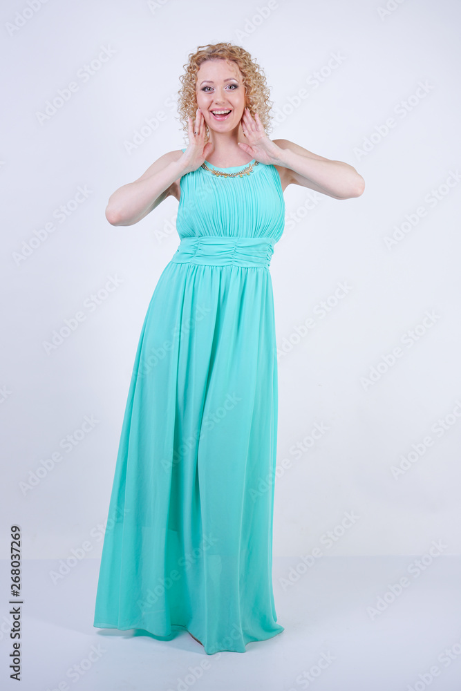 pretty blonde caucasian woman wearing long blue fashion summer dress on white background