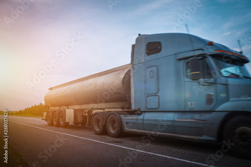 Fuel tanker cargo truck in motion shipping oil, blurred industrial auto as abstract petroleum transportation concept