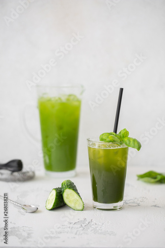 Refreshing cucumber basil lemonade. Poured into a glass and carafe