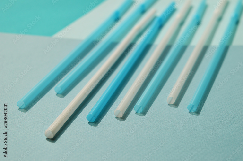 White and blue plastic tubes, turquoise tone. Selective focus, top view. White and blue plastic tubes, turquoise tone. Selective focus, top view.