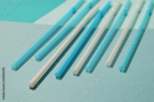 White and blue plastic tubes  turquoise tone. Selective focus  top view.