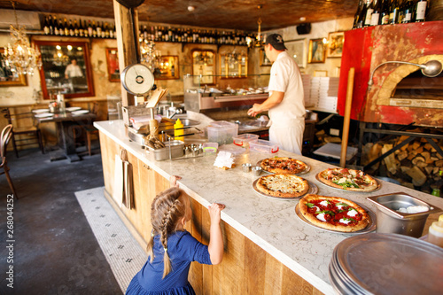 young family dad mom son and daughter eat tasty pizza in a restaurant